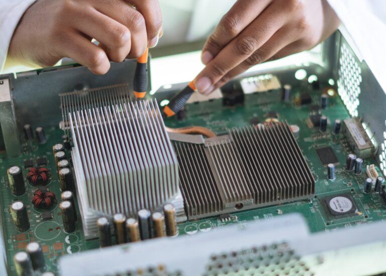 crop-technician-checking-contacts-on-motherboard-in-workshop-3825581